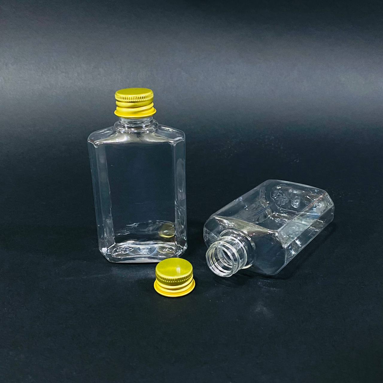 photo_3_2025-01-04_11-42-04 دستة علب بلاستيك مستطيلة شفافة 100 مل 12 شيشة غطاء ذهبي متعددة الاستعمالات - الصورة 1