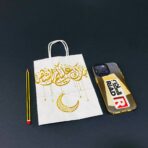 ⁦كيس هدايا ورقي ابيض بعبارة ذهبية مبارك عليكم الشهر مع هلال رمضان⁩ - الصورة ⁦4⁩